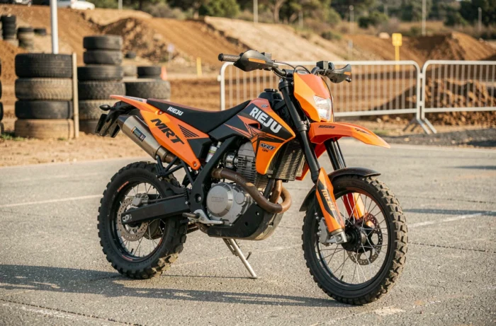 Rieju MRT 125 SM en livrée orange et noire garée sur l'asphalte d'un circuit de supermotard régional espagnol